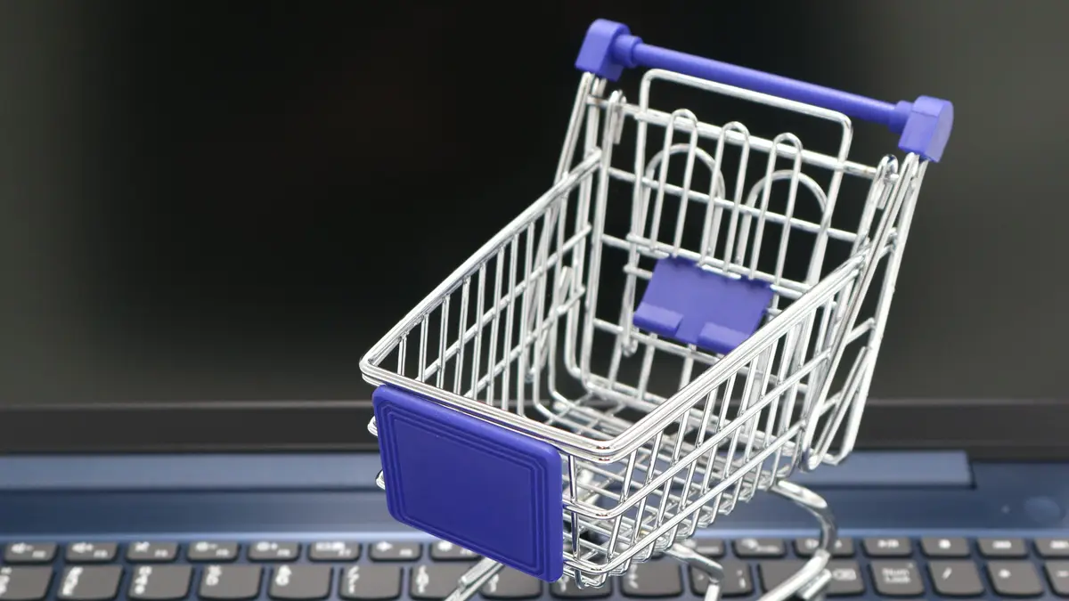 Petit chariot de supermarché posé sur le clavier d'un ordinateur portable