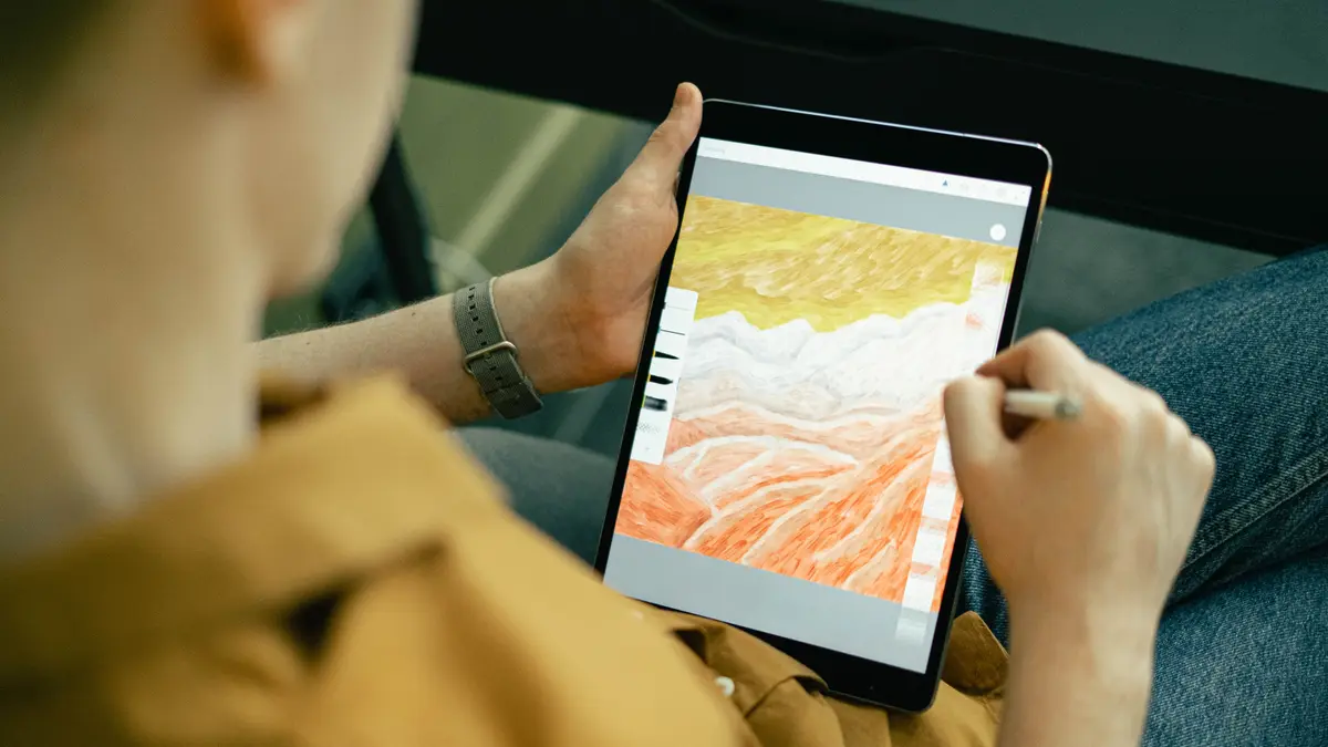 Homme dessinant un paysage sur une tablette avec un stylet
