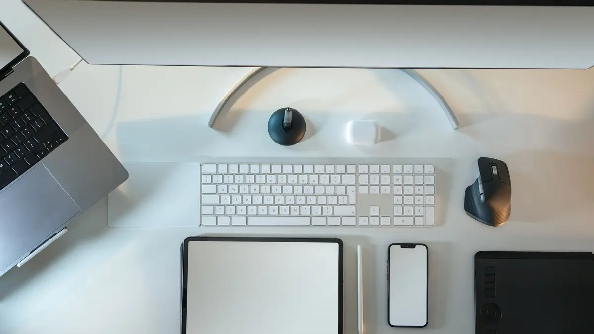 Bureau vu de dessus : tablette, téléphone, clavier, souris et stylet