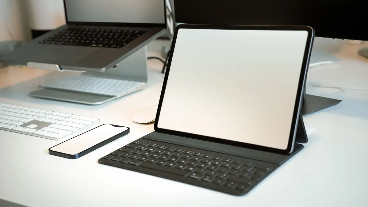 Tablette dans un étui-clavier sur un bureau, devant un ordinateur