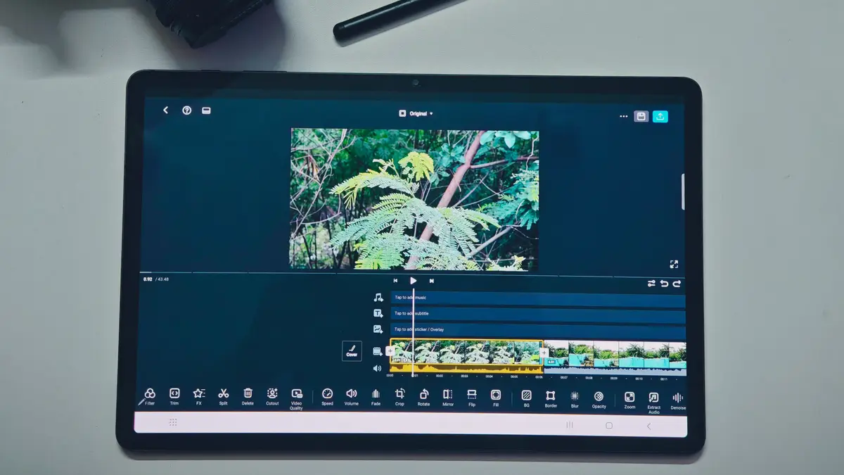 Tablette affichant une timeline de montage vidéo, à côté d'un appareil photo
