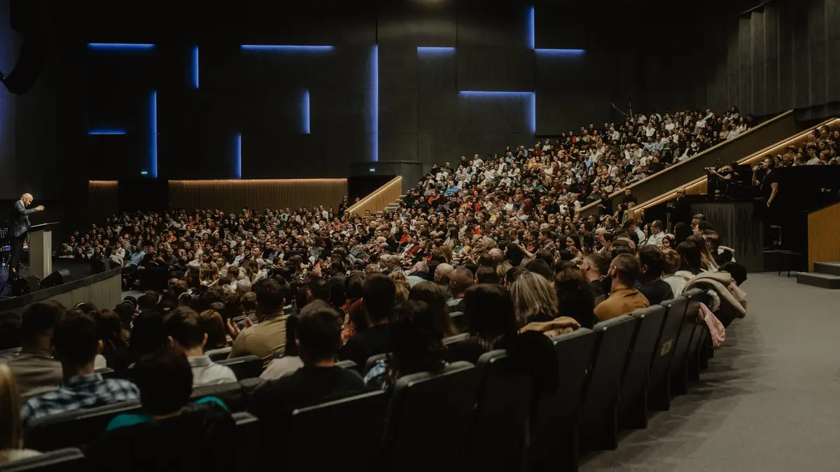 Grand amphithéâtre rempli de spectateurs face à une scène