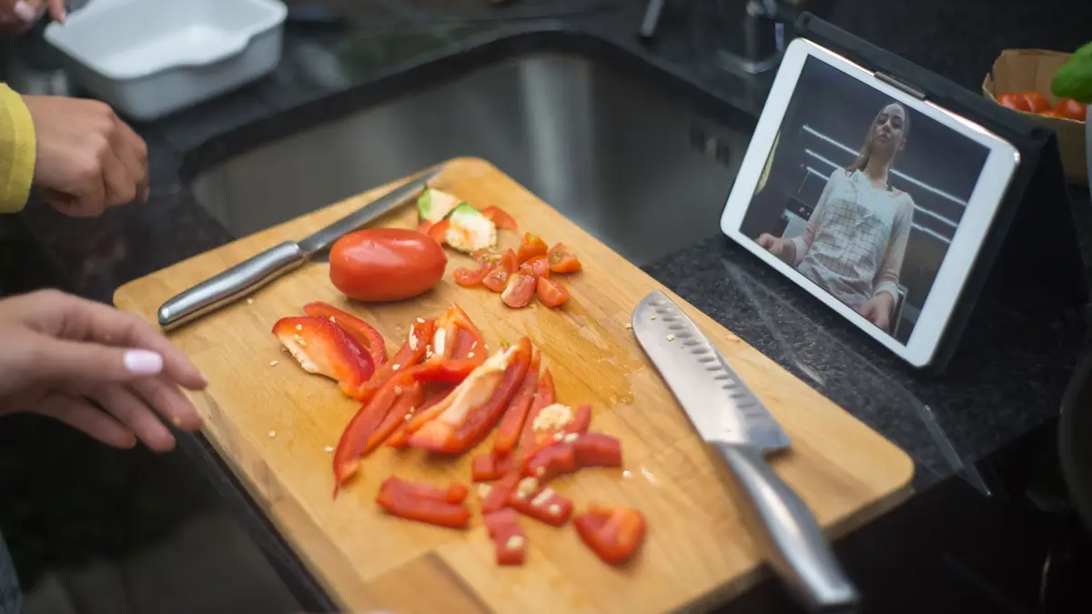 Tablette posée près d'une planche où l'on découpe des poivrons